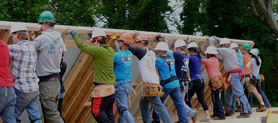 Image description: Staff at TechBridge - an official Exponent Case Management implementation partner - working together to build a home and lift a wall. Source: Techbridge.org